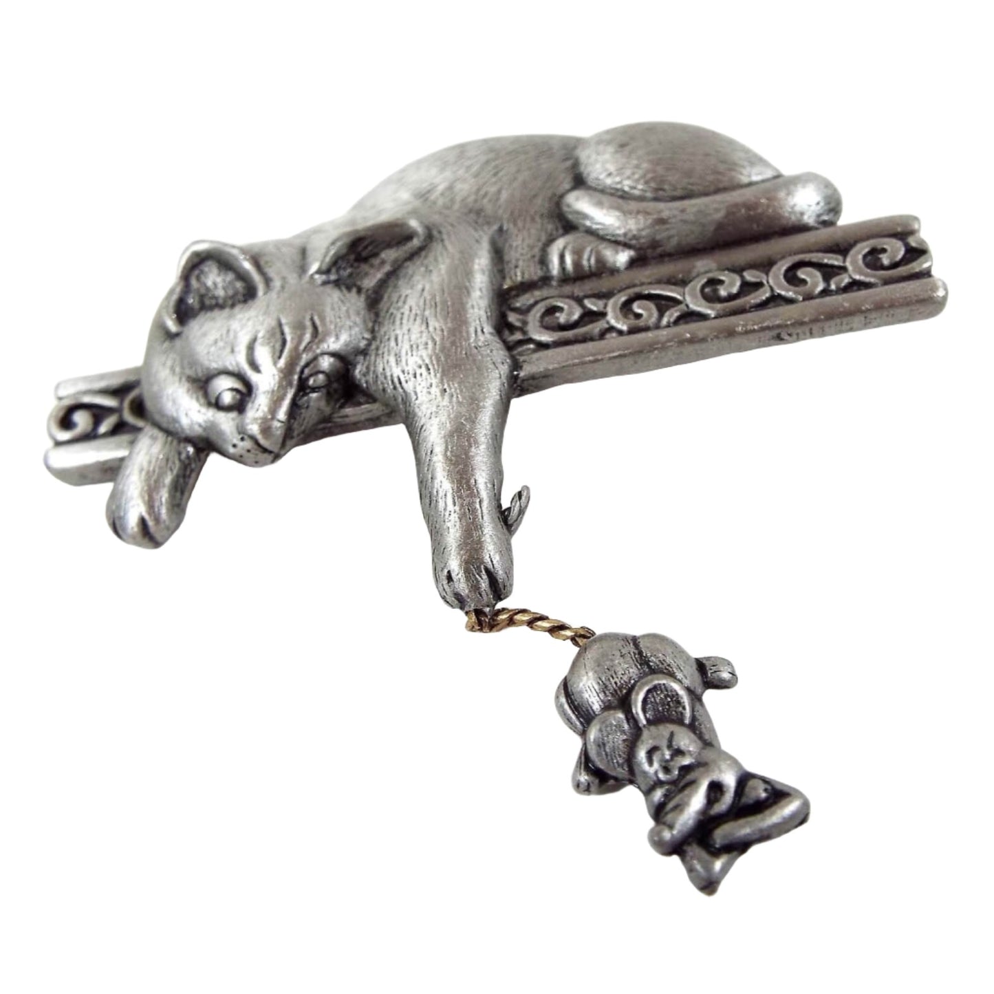 Front view of the retro vintage JJ brooch. The brooch is matte pewter gray color. On the top is a 3D style cat peering down at a mouse and holding it by the tail. The cat is laying on a bar with fancy scroll work design and his paw is hanging down past it. The mouse has a twisted metal tail and has an angry look on his face with his arms folded over one another.