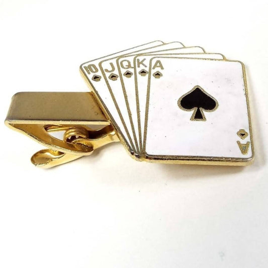 Front view of the retro vintage enameled playing cards tie clip. The metal is gold tone in color. The end has a Poker hand of cards showing a royal flush of spades. The top card shows the Ace of spades and the corners of the other cards in order is King, Queen, Jack, and 10 of spades. 
