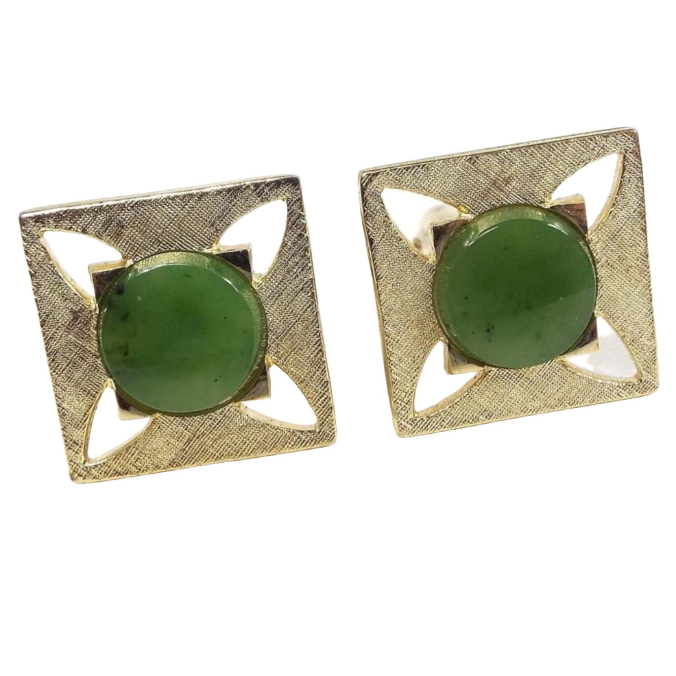 Front view of the Mid Century vintage cufflinks. The cufflinks are square in shape with matte brushed gold tone color metal. The middle cabs are flat round green jade gemstone on top of flat squares. The outer edge has a square design with cut out tapered shapes to the corners of the cufflinks for a nice modernist style design.