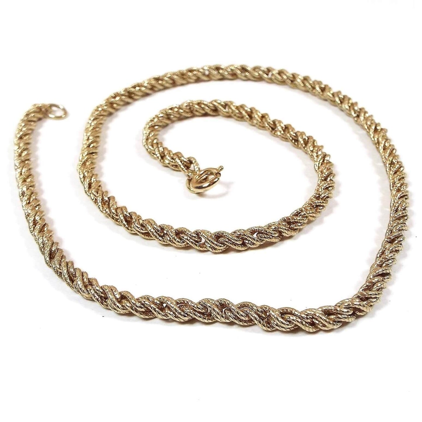 Top view of the retro vintage rope chain. The metal is gold tone in color. Necklace has a twisted rope chain design with a round spring ring clasp at the end.