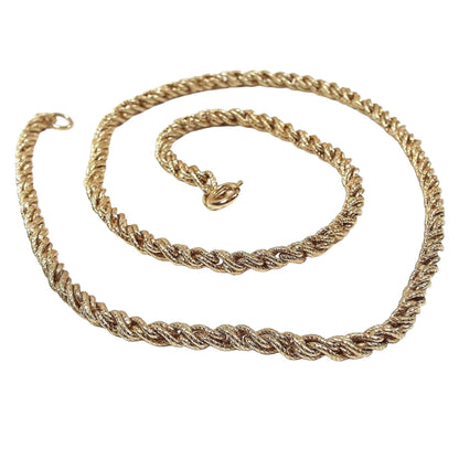 Top view of the retro vintage rope chain. The metal is gold tone in color. Necklace has a twisted rope chain design with a round spring ring clasp at the end.