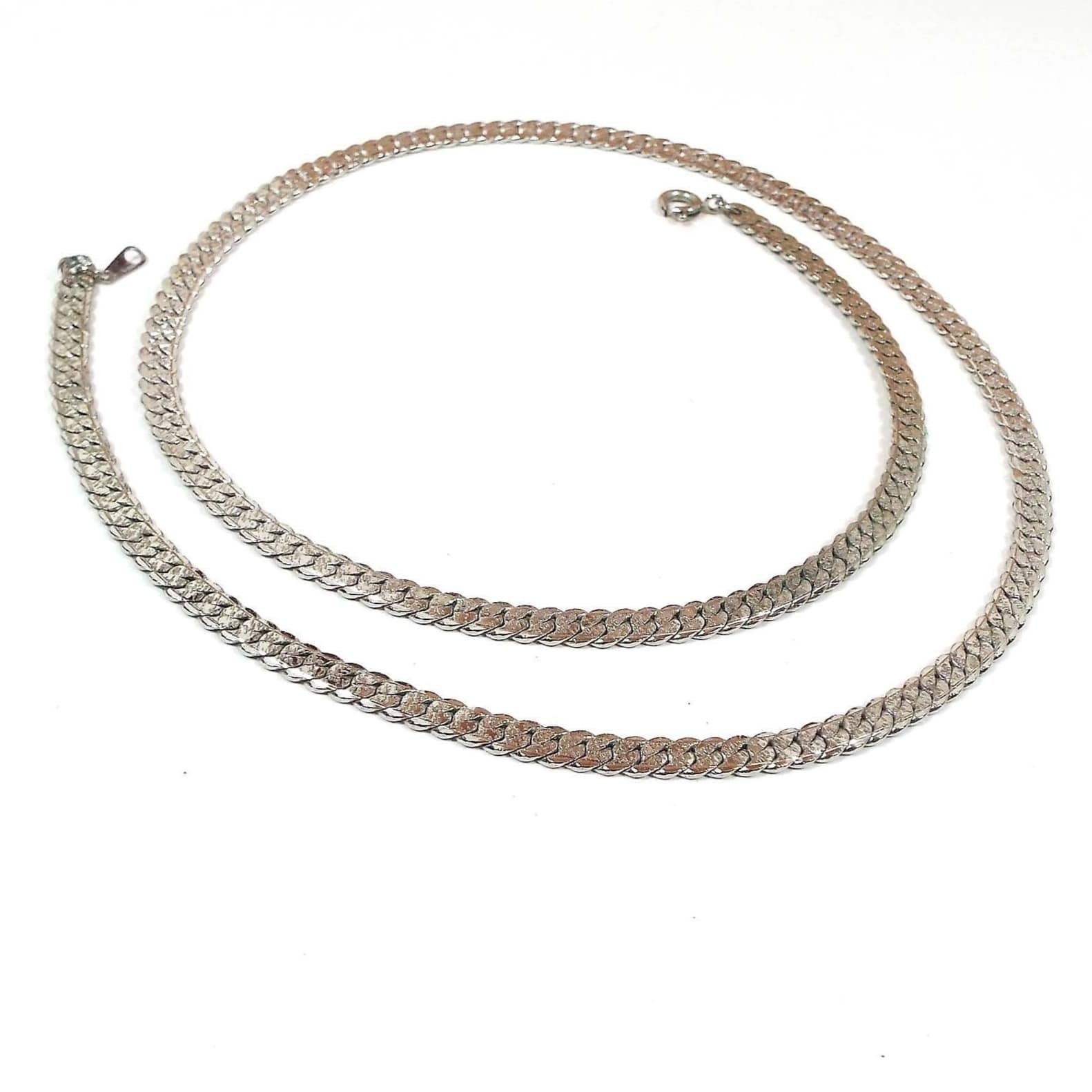 Chain is silver in color with cuban link style. Links are faceted round and sit flat.
