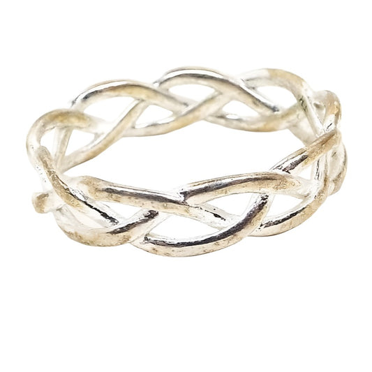 Angled front and side view of the retro vintage IBB TH sterling silver band ring. The ring has an open braided Celtic style design. The silver is slightly darkened from age. 