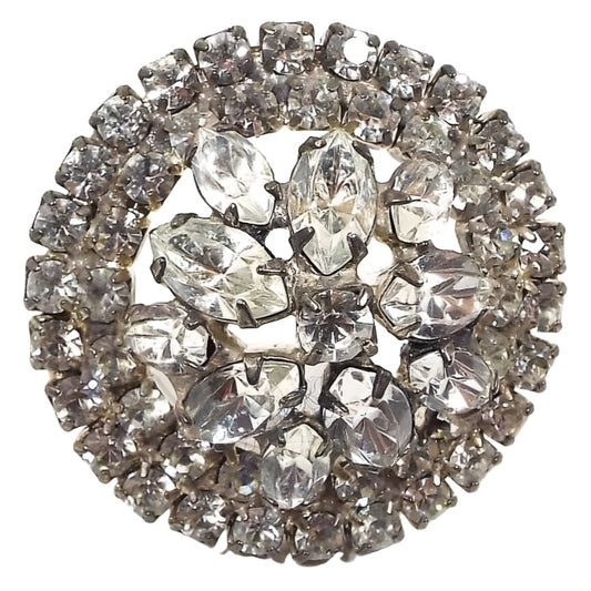 Front view of the 1950's Mid Century vintage rhinestone brooch pin. The metal is silver tone in color. There are two rows of round clear rhinestones all the way around the edge. The middle has various sizes of marquis shape clear rhinestones and there is one round clear rhinestone in the very middle. All rhinestones are prong set. 