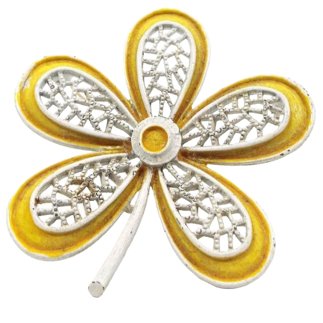 Front view of the 1960's Mid Century vintage Hippie flower brooch pin. It is shaped like a large flower with long rounded petals. The petals have a filigree design. It is white enameled with a yellow enamel edge and center. 