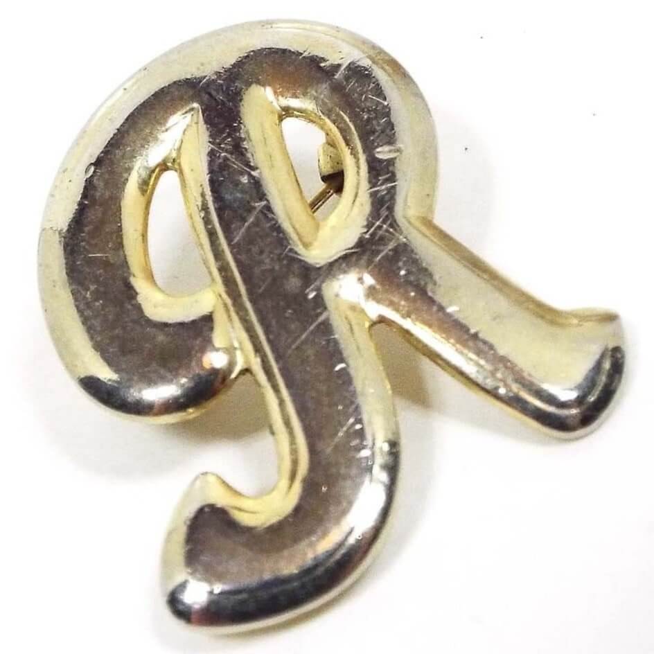 Front view of the Mid Century vintage letter brooch. The metal is gold tone in color. The brooch is a puffy fancy style initial R.
